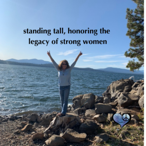 Woman standing in front of lake with quote "Honoring the legacy of strong women"